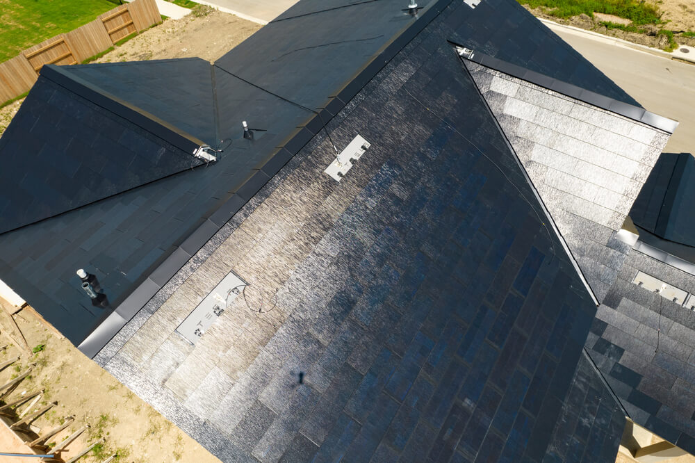Tesla Solar Roof Tile Shingles producing solar energy combined with a Home Powerwall for a sustainable home capable of Off-Grid solar production.