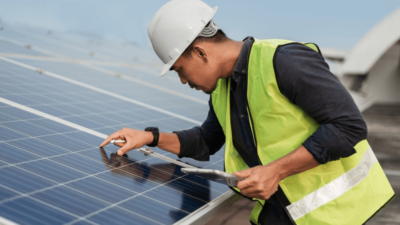 Engineer man checking of solar panels energy with tablet. Technician checking and services of photovoltaic solar panels. Sustainable Energy concept